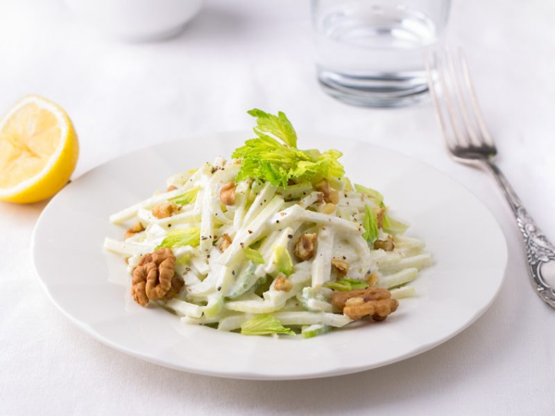 Traditional Waldorf salad with celery, apple, walnut and yoghurt dressing on white background, selective focus, horizontal